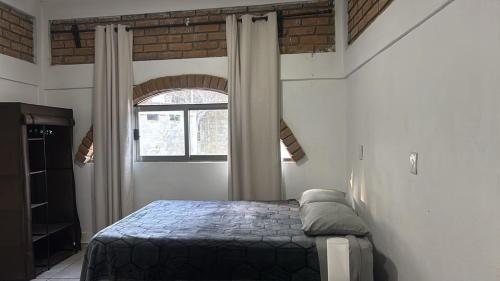 a bedroom with a bed in a room with a window at The best sunrise in Salina Cruz