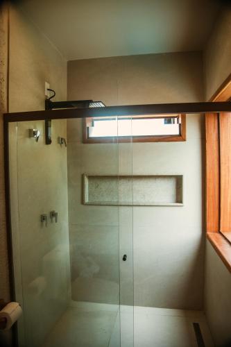 a glass shower in a bathroom with a window at Reserva Mazu in São Miguel dos Milagres