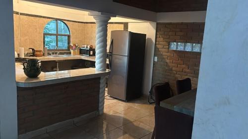 a kitchen with a stainless steel refrigerator and a counter at The best sunrise in Salina Cruz