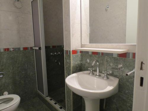 a bathroom with a sink and a shower and a toilet at Hotel Trocadero in Necochea