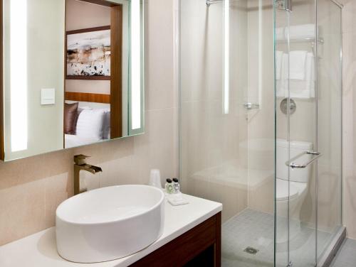 a white bathroom with a sink and a shower at Porter Square Hotel in Cambridge