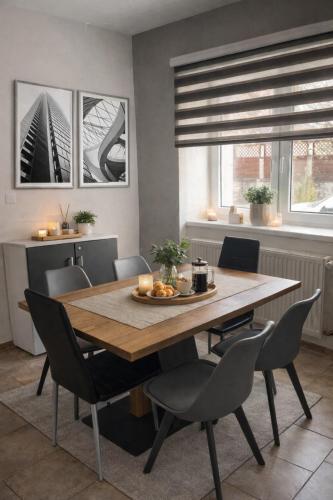 a dining room with a wooden table and chairs at Holiday House Jana in Muráň