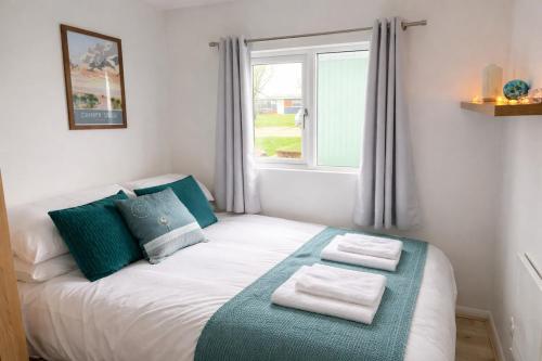 a small bedroom with a bed with towels on it at The Retreat Camber in Camber