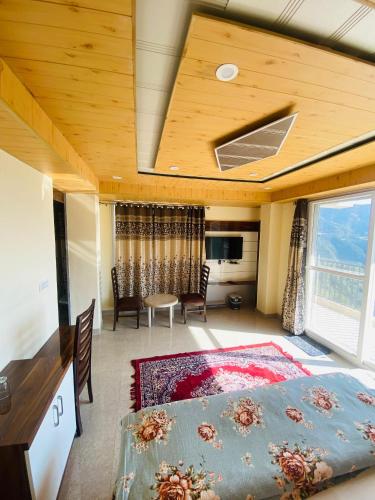 a bedroom with a bed and a table and chairs at Rivervalley View Homestay in Kandāghāt
