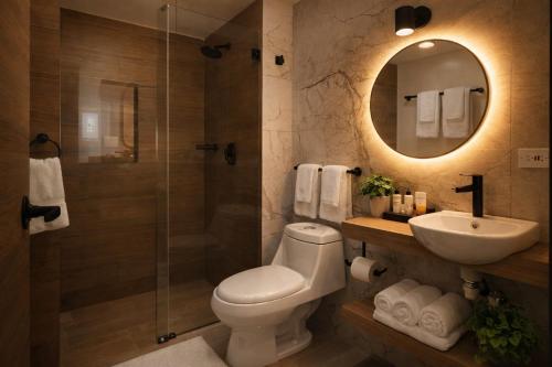 a bathroom with a toilet and a sink and a shower at Durán Business Suites near Airport in Bogotá