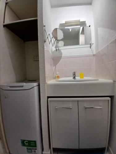 a small bathroom with a sink and a refrigerator at Pointe Saint-Jacques - L'entre deux vagues in Sarzeau