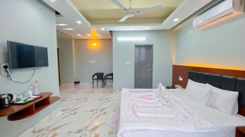 a hotel room with a bed and a flat screen tv at Cloudy Inn Resort in Bāndarban