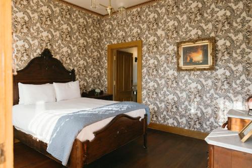 a bedroom with a bed and a wall covered in wallpaper at Cosmopolitan Hotel in San Diego