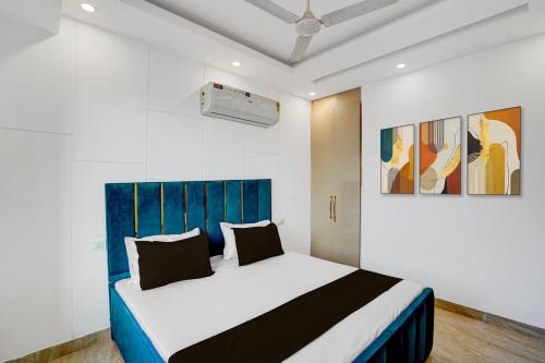 a bedroom with a large bed with a blue headboard at Hotel O Maxico in New Delhi