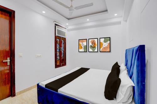 a bedroom with a bed with blue and white walls at Hotel O Maxico in New Delhi