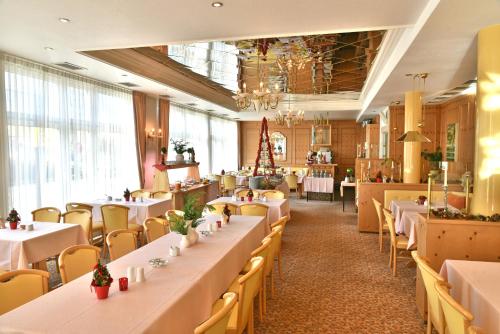 ein Esszimmer mit weißen Tischen und Stühlen in der Unterkunft Hotel Dorotheenhof in Cottbus