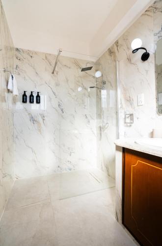 a white bathroom with a shower and a sink at Casa Alba Modern Boho Villa with private Pool near to Sea, Paphos in Peyia