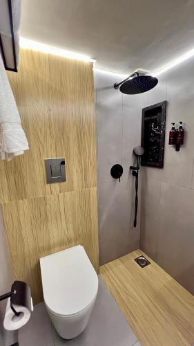 a bathroom with a white toilet and a light at Aurhom By Royal Inn in Karachi