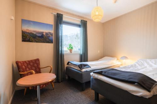 a bedroom with two beds and a table and a window at Yttersia Base in Senja
