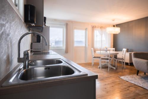 a kitchen with a sink and a dining room at Yttersia Base in Senja