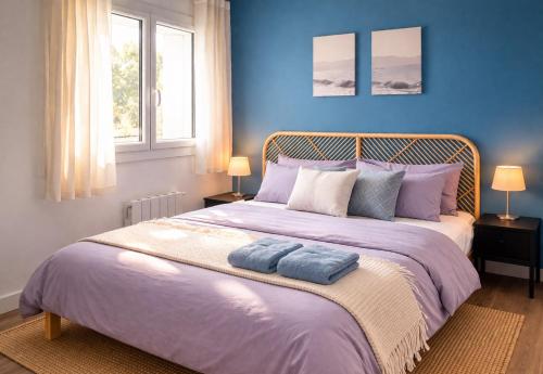 a blue bedroom with a large bed with two towels on it at Le refuge Marin - Mer, Piscine, tennis & Loisirs à 2 pas in Cabourg