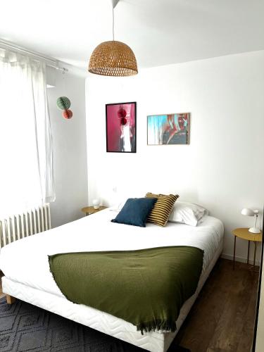 a bedroom with a large bed with a green blanket at Au perron avec garage et balcon à Ribeauville in Ribeauvillé