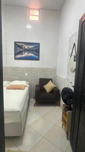 a small bedroom with a bed and a chair at Casa Borges leal in Santarém