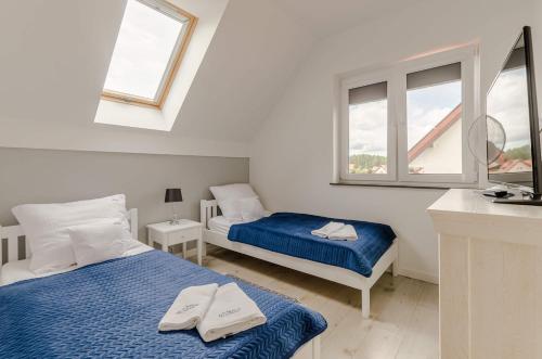 a bedroom with two beds and two windows at Ryn - Rybical Resort in Rybical