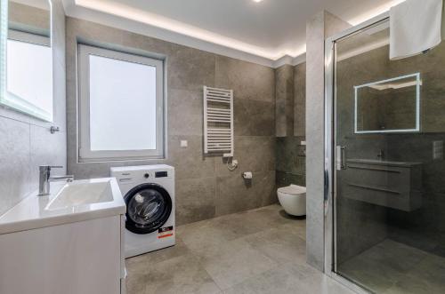 a bathroom with a washing machine next to a toilet at Ryn - Rybical Resort in Rybical