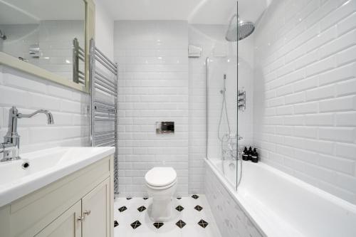 a white bathroom with a toilet and a sink at Idyllic Waterside Cottage in Mid Devon in Tiverton