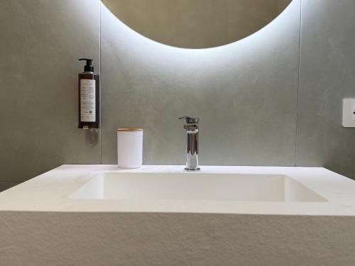 a bathroom sink with a soap dispenser and a bottle at Ferraro Apartments in Campora San Giovanni