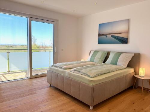 a bedroom with a bed and a large window at Villa 60, luxuriöse Villa mit Pool, Sauna und großem Garten in Gols