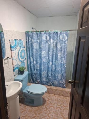 a bathroom with a blue toilet and a sink at Casa Del Mar Pedasí in Pedasí Town