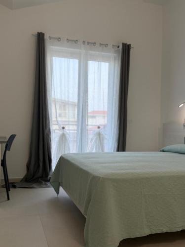 a bedroom with a bed and a large window at Ferraro Apartments in Campora San Giovanni