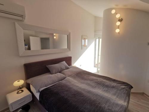 a bedroom with a bed and a mirror on the wall at Golf & Meer - Appartment im Skiper Resort in Crveni Vrh
