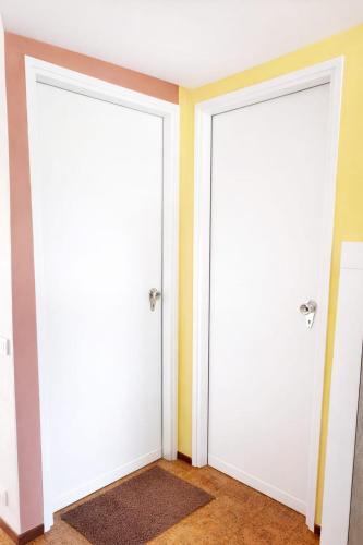 two doors in a room with yellow walls at Residenza Cornicello in Bardolino