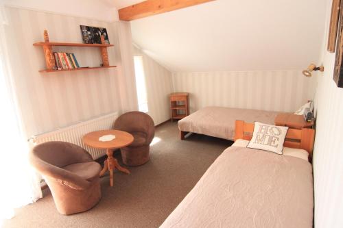 a bedroom with a bed and chairs and a table at Anmar Pokoje Narty Rowery in Stronie Śląskie