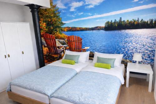 a bedroom with two beds and a view of a lake at Apartamenty Welskie in Lidzbark