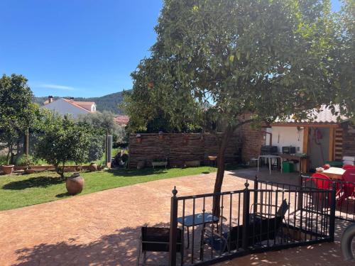 a garden with a fence and a tree at La Casa Del Sastre in Torrecilla de los Ángeles