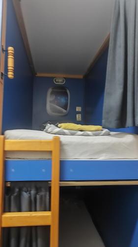 a small bed in a small room with a window at Лидер Хаус хостел in Varna City