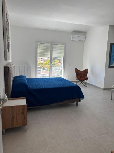a bedroom with a blue bed and a chair at Villa Lina in Agrigento