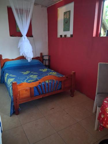 a bedroom with a bed in a red wall at Chez Brahim in Pointe-à-Pitre