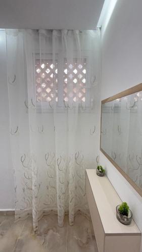 a bathroom with a white shower curtain and a mirror at Olivia Loft in Birmandreis