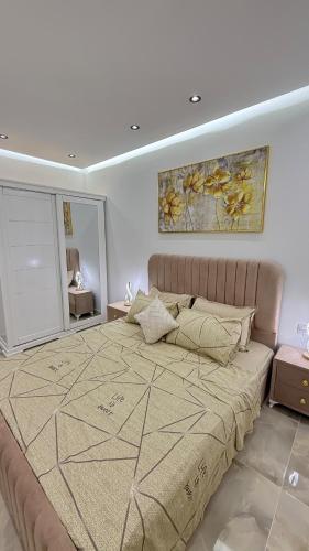 a bedroom with a large bed and a painting on the wall at Olivia Loft in Birmandreis