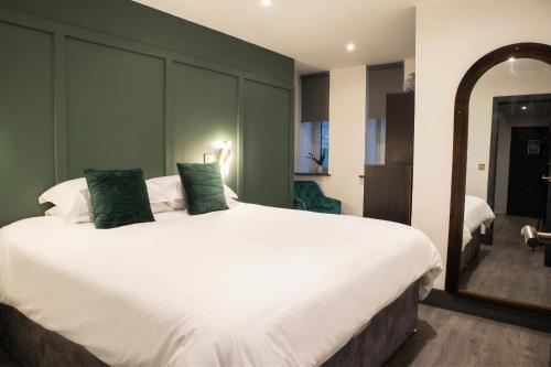 a bedroom with a large white bed with green walls at Luxury Serviced Apartment With Super King Bed Workspace WiFi & Netflix Washer Dryer Close Parking in Bradford