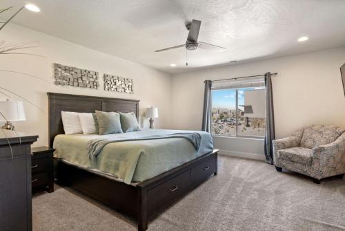 a bedroom with a bed and a chair and a window at Townhome Near Zion with Hot Tub & Pool in Washington