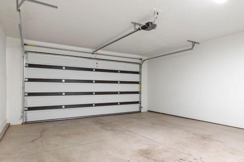 an empty garage with white walls and metal garage doors at Townhome Near Zion with Hot Tub & Pool in Washington
