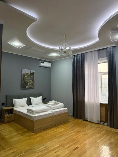 a bedroom with two beds and a chandelier at ART Dream Hotel in Tashkent