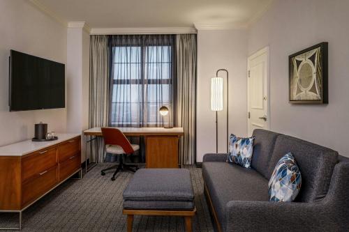 a living room with a couch and a desk at Courtyard by Marriott Boston Downtown in Boston