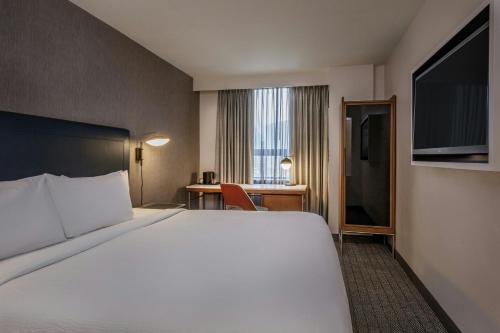 a hotel room with a large bed and a desk at Courtyard by Marriott Boston Downtown in Boston