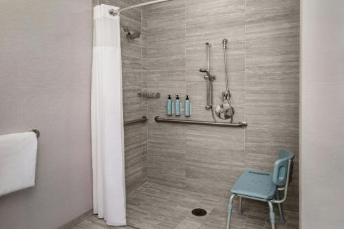 a shower with a blue chair in a bathroom at Courtyard by Marriott Boston Downtown in Boston