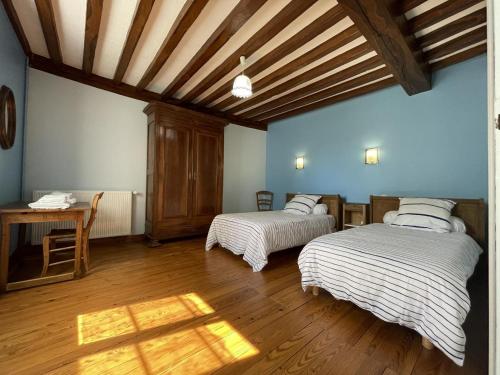 a bedroom with two beds and a wooden floor at Etchechoury in Moncayolle-Larrory-Mendibieu