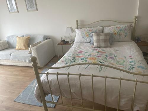 a bedroom with a bed and a couch at Estuary's Rest Studio Apartment at Galwad Y Mor in Cardigan