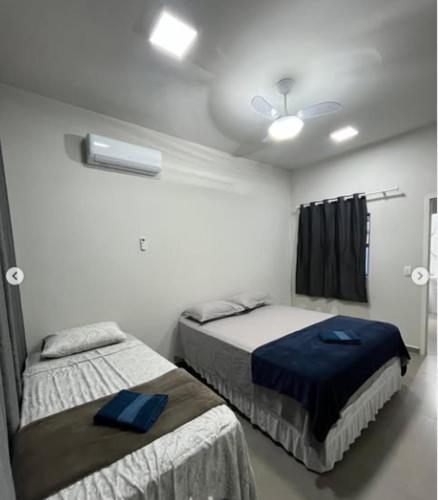 a bedroom with two beds and a ceiling at N 40 - Central com 2 quartos, ar condicionado e garagem in Cascavel