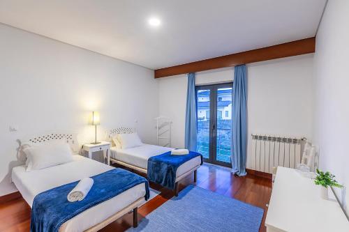 a bedroom with two beds and a large window at HI Douro Alijó - Pousada de Juventude in Alijó